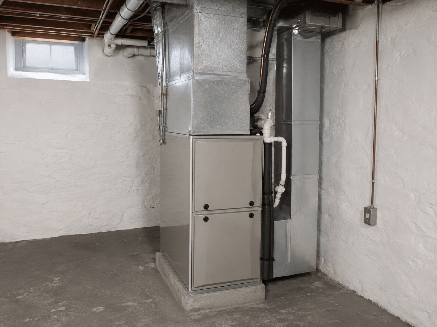 An indoor air handler with ductwork in a basement