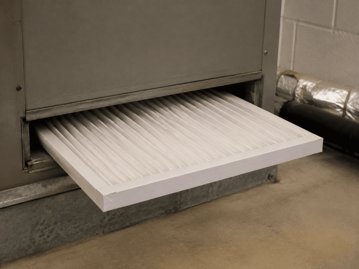 A pleated air filter partly inserted into the filter rack of an indoor unit